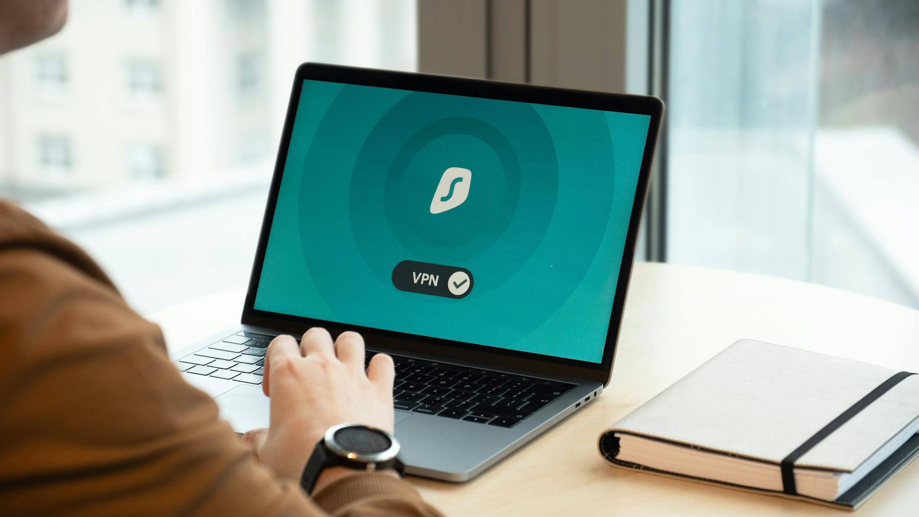 Laptop displaying VPN interface beside a shield icon, representing NordVPN and ExpressVPN comparison in 2026.